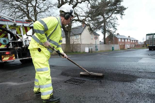 Nigel Baines from Nuphalt Contracting tidying up a filled-in pothole's edges.