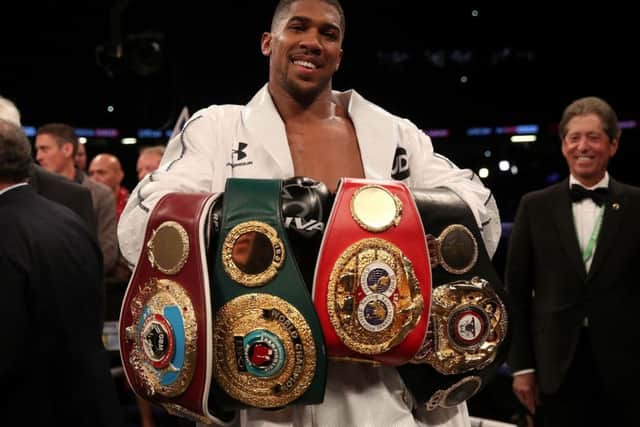 Anthony Joshua celebrates with his belts after victory over Joseph Parker
