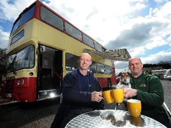 Adam Pope and Lucien Burkhardt at the boatyard pictured with dog Rosie. They are hoping to convert a double-decker bus into a cafe by the canal