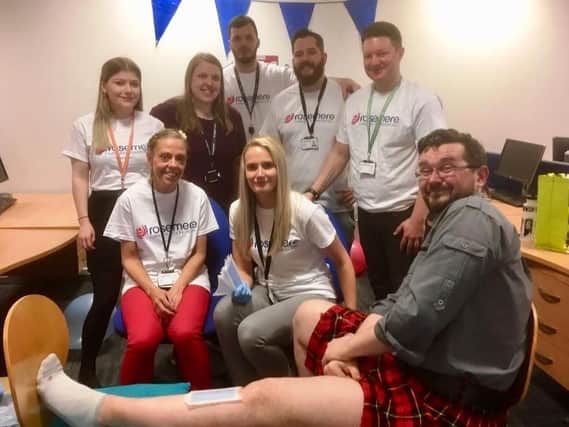 Steve Hardy (seated) has  his leg hair waxed for Rosemere Cancer Foundation watched by Capita colleagues, from the left, Emma Whitemoss, Eleanor Davies, Matthew Harriosn, Mark Lee, Leah Broadbent, Shaun Orphan and Nicola Smith