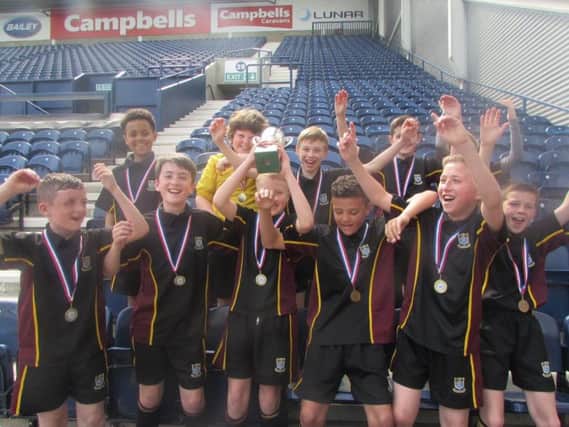 Or Lady's High School Under-12s lift the Mick Baxter Cup at Deepdale