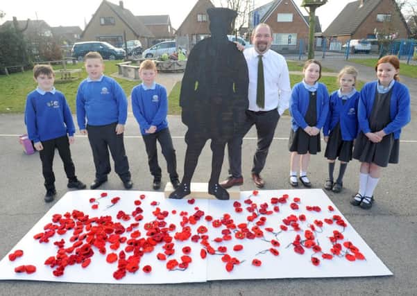 Poppies which have already been collected at Barnacre Road Primary.  Pictured are pupils Barney Winder, Issac Billington, Joshua Birch, Imogen Strickland, Beth Maddock and Shannon Ball with headteacher Simon Wallis.