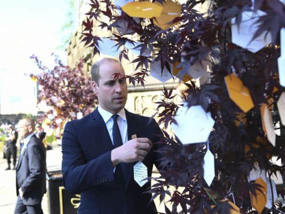 Prince William leaves a message on a 'Tree of Hope' in Manchester
