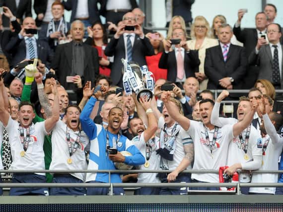 John Welsh and Tom Clarke lift the League One play-off trophy after Preston's win over Swindon at Wembley