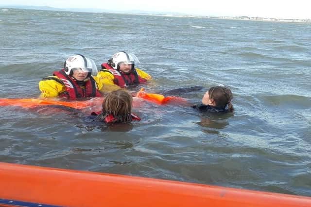 RLNI Volunteer crew members Antony Smith and Conor McIntyre and from British Divers Marine Life Rescue Sara Neill and Marisol Collins releasing the porpoise safely back to sea