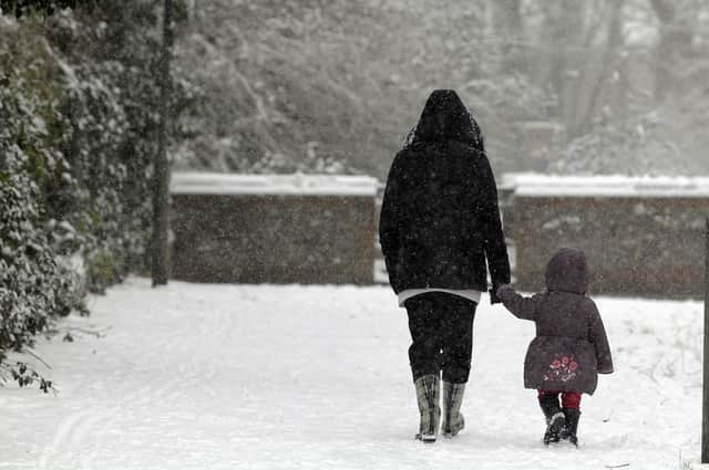 A mother holding her daughter's hand in the snow (Photo: Shutterstock)